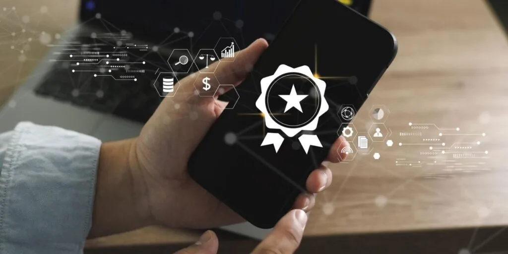 Hand hält ein Smartphone mit einem Prüfsiegel auf dem Bildschirm, umgeben von Sicherheitssymbolen